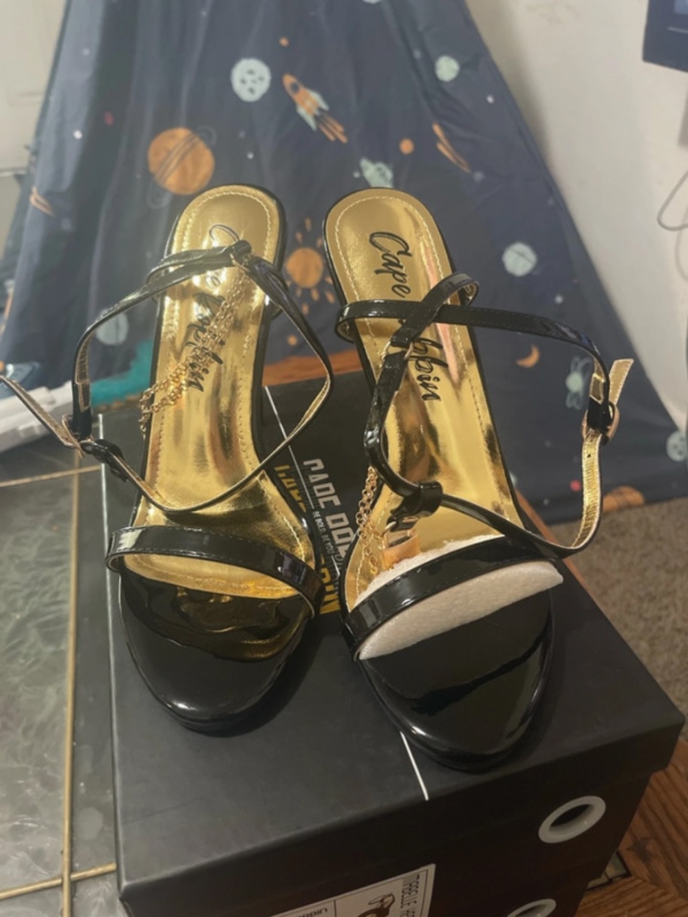 Black stiletto heels with gold chain accent
